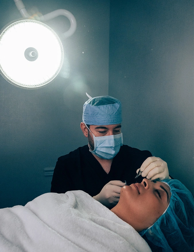 Surgeon performing hair transplant procedure on patient under surgical light in medical clinic - Scar revision in Parsippany, NJ.