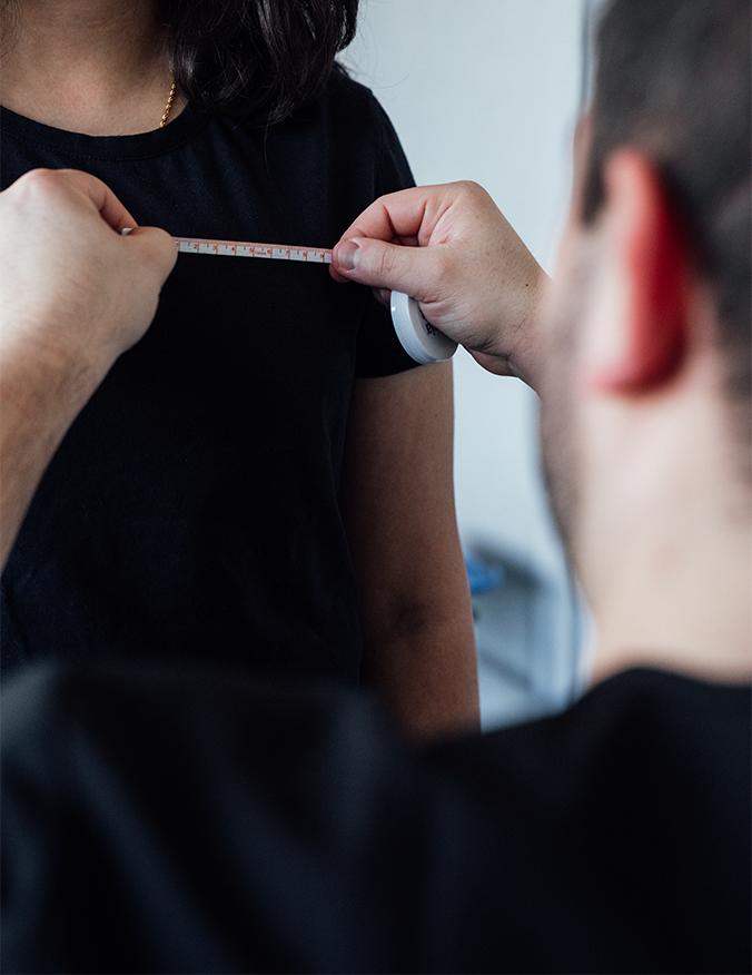 Plastic surgeon measuring patient's chest with measuring tape during breast augmentation consultation - Breast augmentation with lift in Parsippany, NJ.