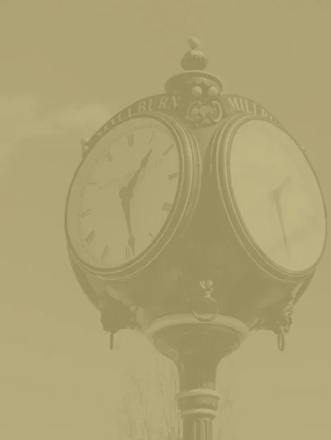 Vintage street clock with ornate details and dual faces in sepia tone